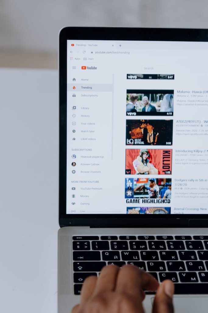 Person browsing YouTube videos on a laptop, showcasing modern technology and online content.